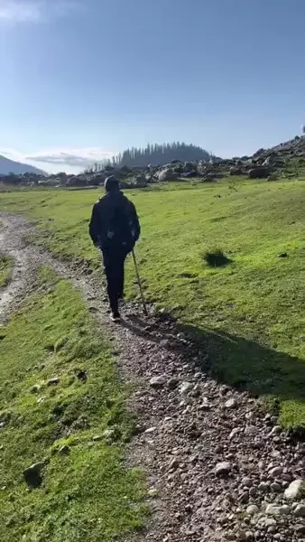 A walker on a sunny mountain trail